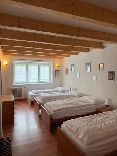 a room with three beds and a window at Al Montel - Tre faggi in Borgo