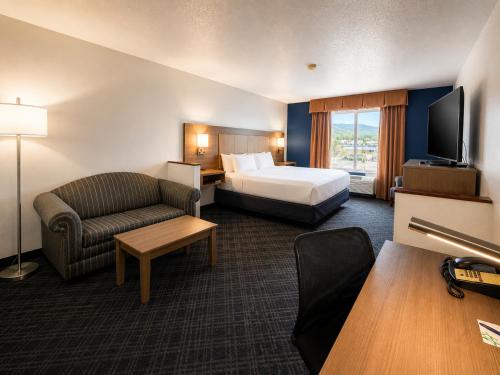 a hotel room with a bed and a couch at Stay USA Hotel and Suites in Hot Springs