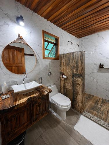 a bathroom with a wooden sink and a toilet at Refúgios de Mauá - Chalé Jardins de Maria in Visconde De Maua