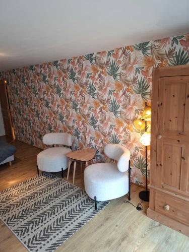 a room with two chairs and a table and a wall at La parenthèse in Puy-dʼArnac
