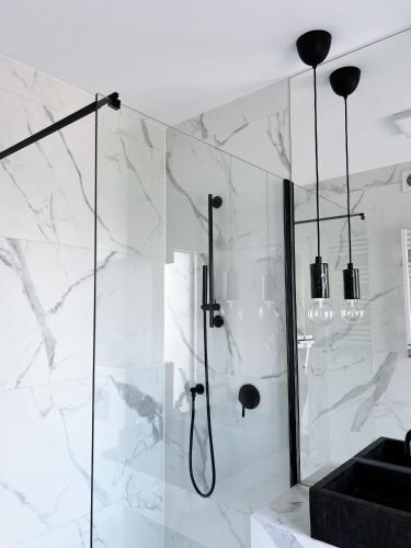 a bathroom with a shower with white marble at powiew - b&b pensjonat noclegi Świnoujście - Unterkunft Swinemünde - guesthouse tennis garden breakfast at baltic sea in Świnoujście