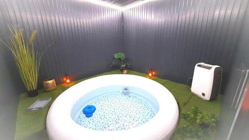 a bathroom with a bath tub with a toilet at LIntemporel in Saint-Sornin