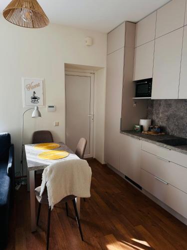 a kitchen with a table and chairs in a room at Apartamentai Vetrungiu g 3 in Nida
