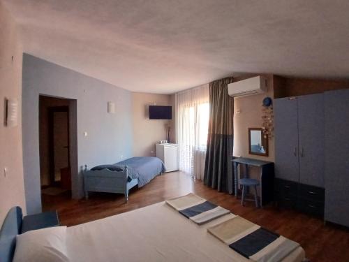 a bedroom with a bed and a desk in it at Zenith Guest House in Sozopol