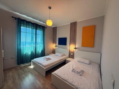 a room with two beds and a window at Privat Pool Garden Villa in Gjilek