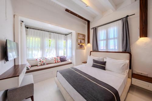 a bedroom with a bed and a window at B House Alaçatı in Alaçatı
