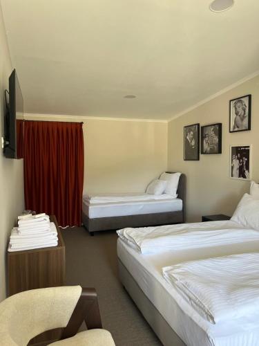 a hotel room with two beds and a chair at Conty in Vršac