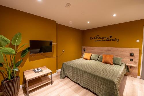 a bedroom with a bed and a flat screen tv at Hotel Onder De Linden in Roden