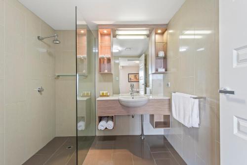 y baño con lavabo y ducha. en CBD Executive Apartments en Rockhampton