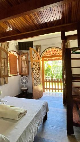 a bedroom with a bed and an open doorway at POUSADA JOSÉ DA ROSA in Santo Antônio do Pinhal