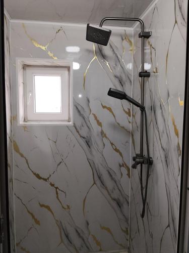 a bathroom with a shower with a window at Nice Hostel in Sary-Mogul