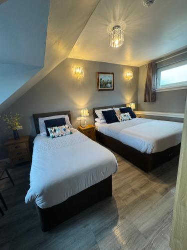a hotel room with two beds and a window at The Milton Accommodation in Elgin