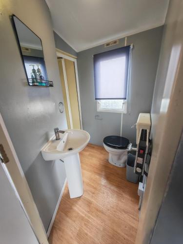 a bathroom with a sink and a toilet at 237 Sealands, 6 Birth caravan in Ingoldmells