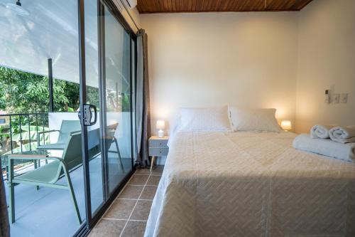 a bedroom with a bed and a balcony at Mango Coliving Apartments for Digital Nomads in Uvita