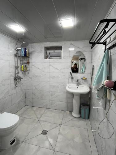 a white bathroom with a sink and a toilet at Gusar bungalow in Qusar