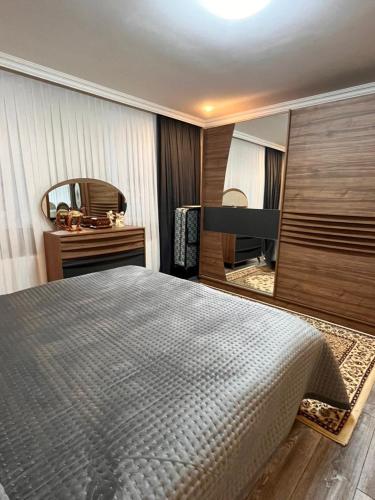 a bedroom with a large bed and a mirror at Gusar bungalow in Qusar