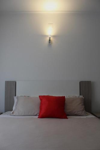 a red pillow sitting on top of a bed at Casa Barbeiro in Pombal