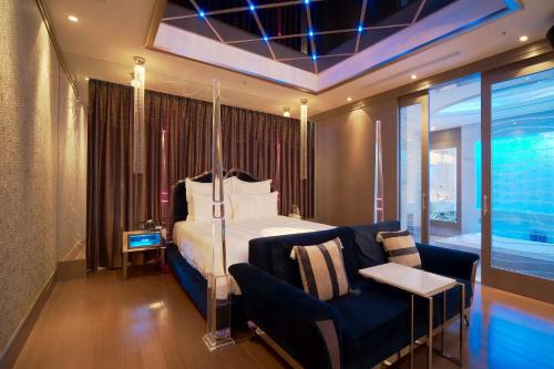 una camera con letto, divano e sedia di Wego-Hsinchu Boutique Hotel a Hsinchu