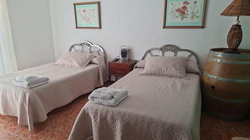a bedroom with two beds and a table with a lamp at Pensión Isasa in Arnedo