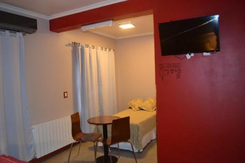 a room with a bed and a flat screen tv on a wall at EL Molle Hotel Boutique in Sarmiento
