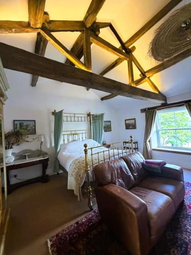 a living room with a bed and a couch at Burnlee House Apartment in Holmfirth