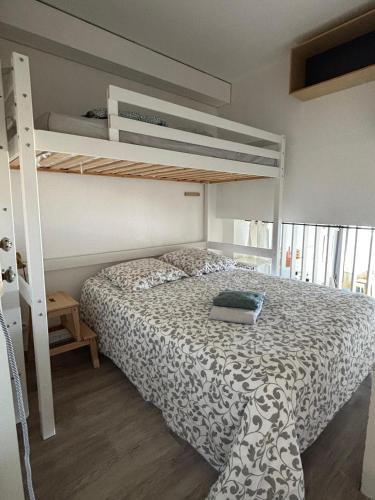 a bedroom with a bunk bed with a laptop on it at Duplex vue mer et accès plage in Arcachon