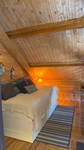 a bed in a room with a wooden ceiling at Chalet scandinave in Xonrupt-Longemer
