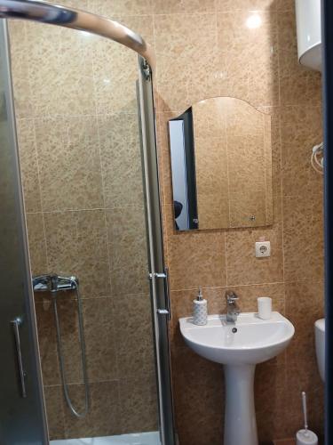 a bathroom with a sink and a shower with a mirror at Optimal in Vyshneve