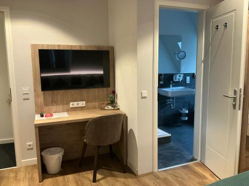 a bathroom with a desk with a television and a sink at VillaWie in Rheda-Wiedenbrück