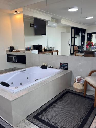 a large white bath tub in a room at Hotel Flor de Minas in Uberaba