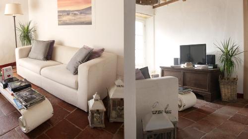 a living room with a white couch and a tv at Rustico Dora in Camaiore