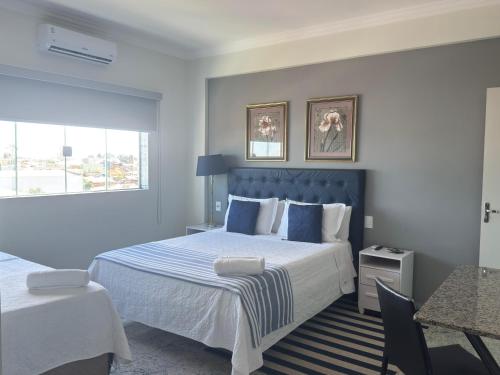 a hotel room with a large bed and a window at Hotel Flor de Minas in Uberaba