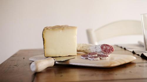a piece of cheese on a cutting board on a table at Rustico Dora in Camaiore