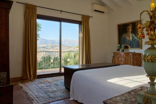a bedroom with a bed and a large window at Villa Camilla in Comares