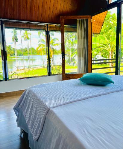 a bedroom with a bed with a view of the water at Jungle Lake View Cabana in Udawalawe