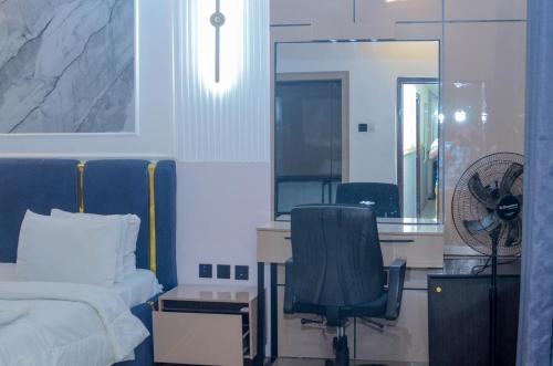 a bedroom with a bed and a desk and a chair at Henry George Hotel Ltd in Idimu