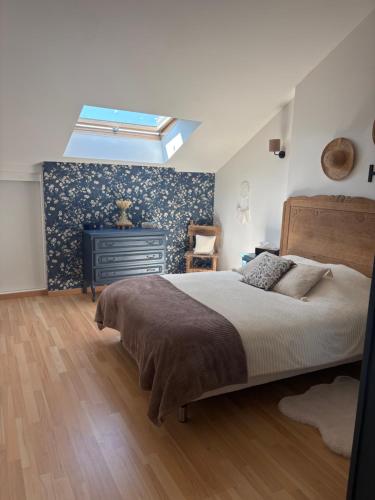 a bedroom with a large bed and a skylight at Petit cocon à 5 min du château de Sedan in Sedan