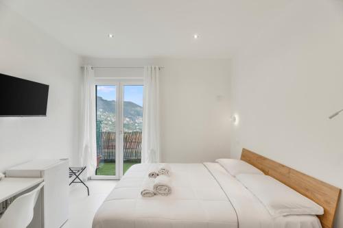 a white bedroom with a bed and a window at B&B Santa Maria in Agerola