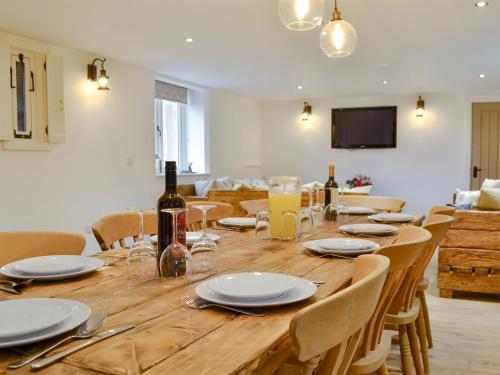 a long wooden table with chairs and a bottle of wine at Ey Up - Uk11447 in Skipsea