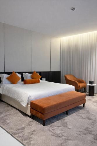 a bedroom with a large bed and two chairs at LeChateau Boutique Hotel in Jeddah