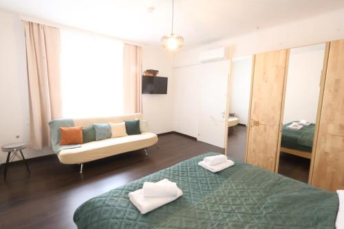 a living room with a bed and a couch at Appartementhaus Ludwig in Mörbisch am See