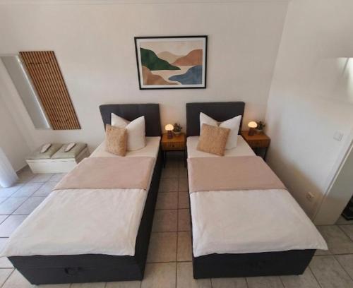 two beds in a room with two lamps at Apartment Julia in Bad Orb