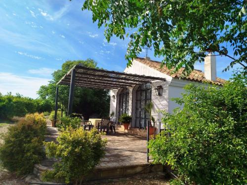 a white house with a pergola in front of it at Casa Rural del Guadalora in Hornachuelos