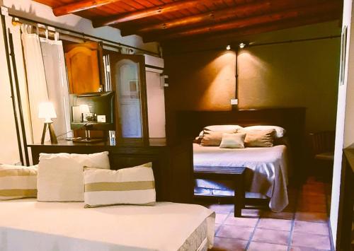 a bedroom with two beds with white sheets at GuardiaPiemontese Aparts in Capilla del Monte