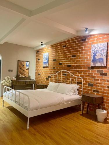 a bed in a room with a brick wall at Oasis Rest ae in Madīnat an Nahḑah