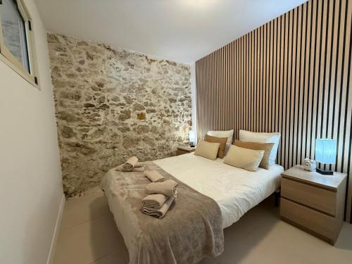 a bedroom with a bed and a stone wall at La Ferronnerie Cassis centre in Cassis