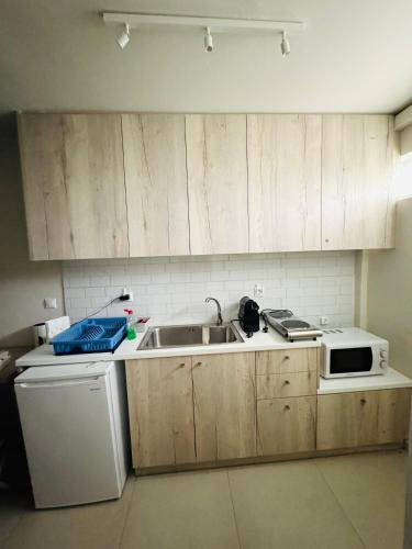 a kitchen with a sink and a microwave at Sophia's studio in Saronida
