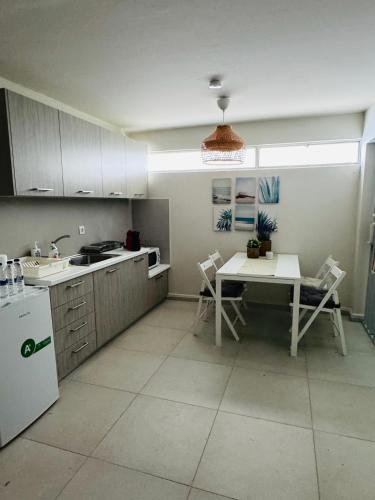 a kitchen with a table and a sink and a refrigerator at Sophia's apartment in Saronida