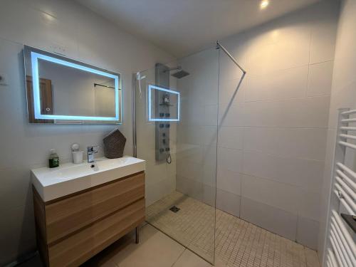 a bathroom with a sink and a shower with a mirror at La Ferronnerie Cassis centre in Cassis
