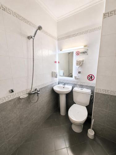 a bathroom with a toilet and a sink at Hotel Cheap - Smart choice - Great value in Sofia